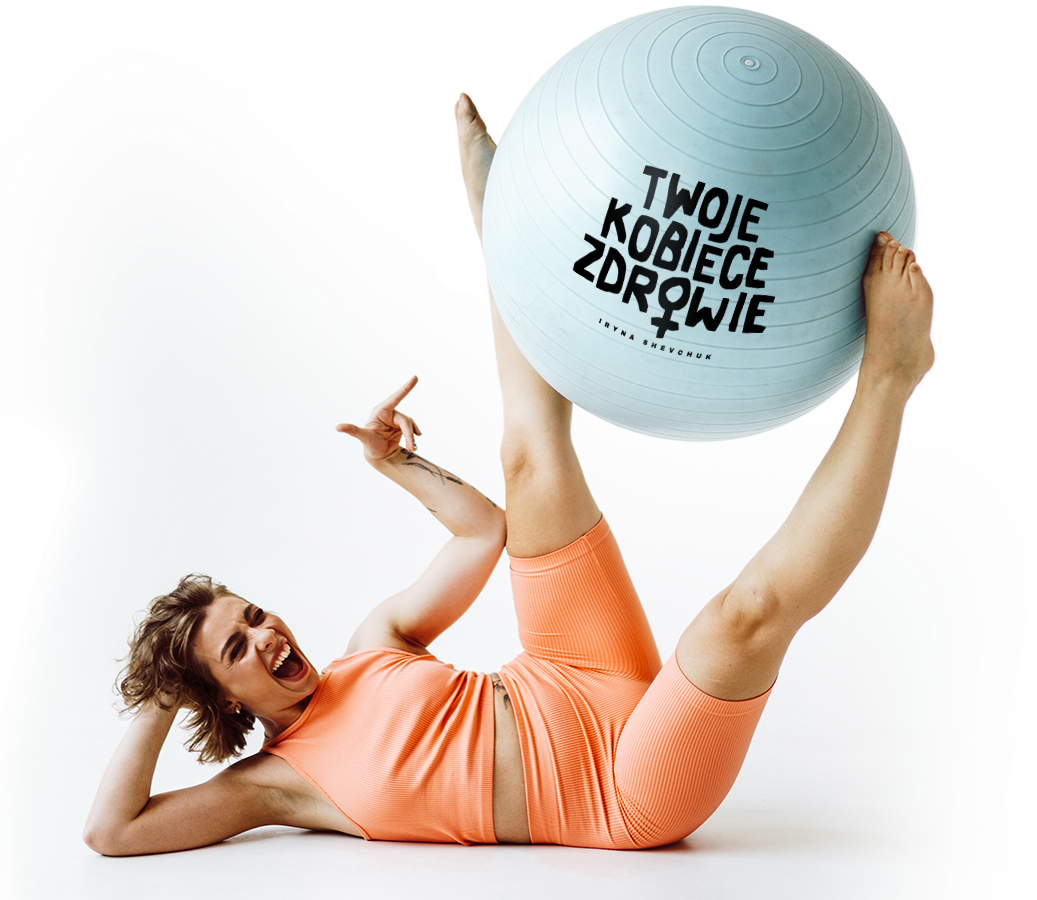 Kobieta w pomarańczowym stroju fitness z piłką gimnastyczną